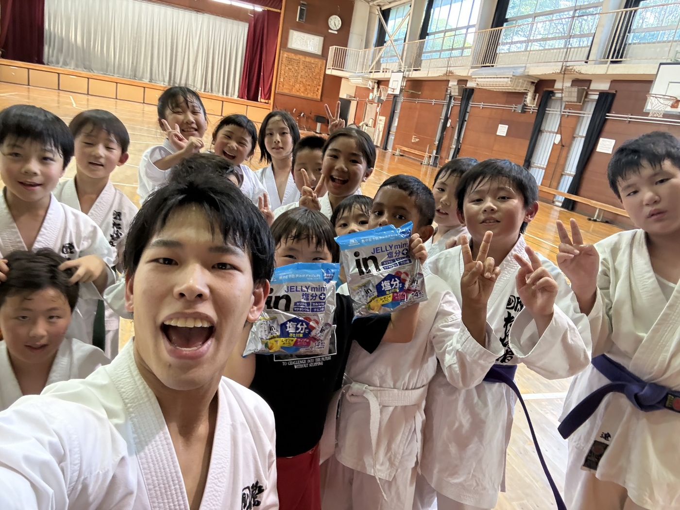 稽古のあと、指導員と一緒に写真におさまる少年部の門下生たち